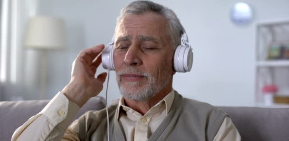 Old man in headphones listening to romantic song, remembering love feelings | Barrett Media Headphones