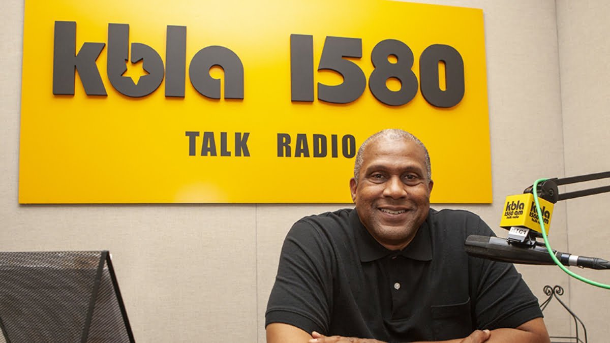 A photo of Tavis Smiley in front of the KBLA logo