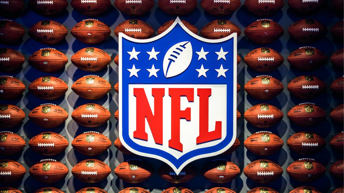 A photo of the NFL logo with a wall of footballs