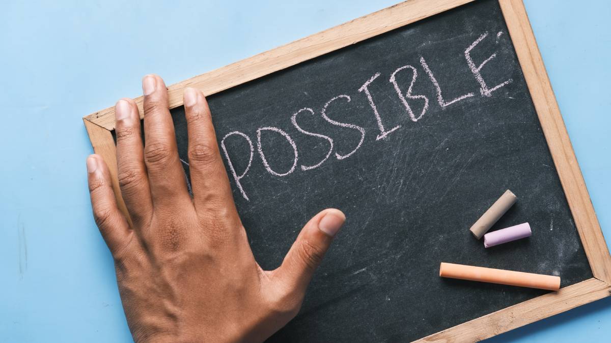 A photo of a chalkboard with the word Possible written on it