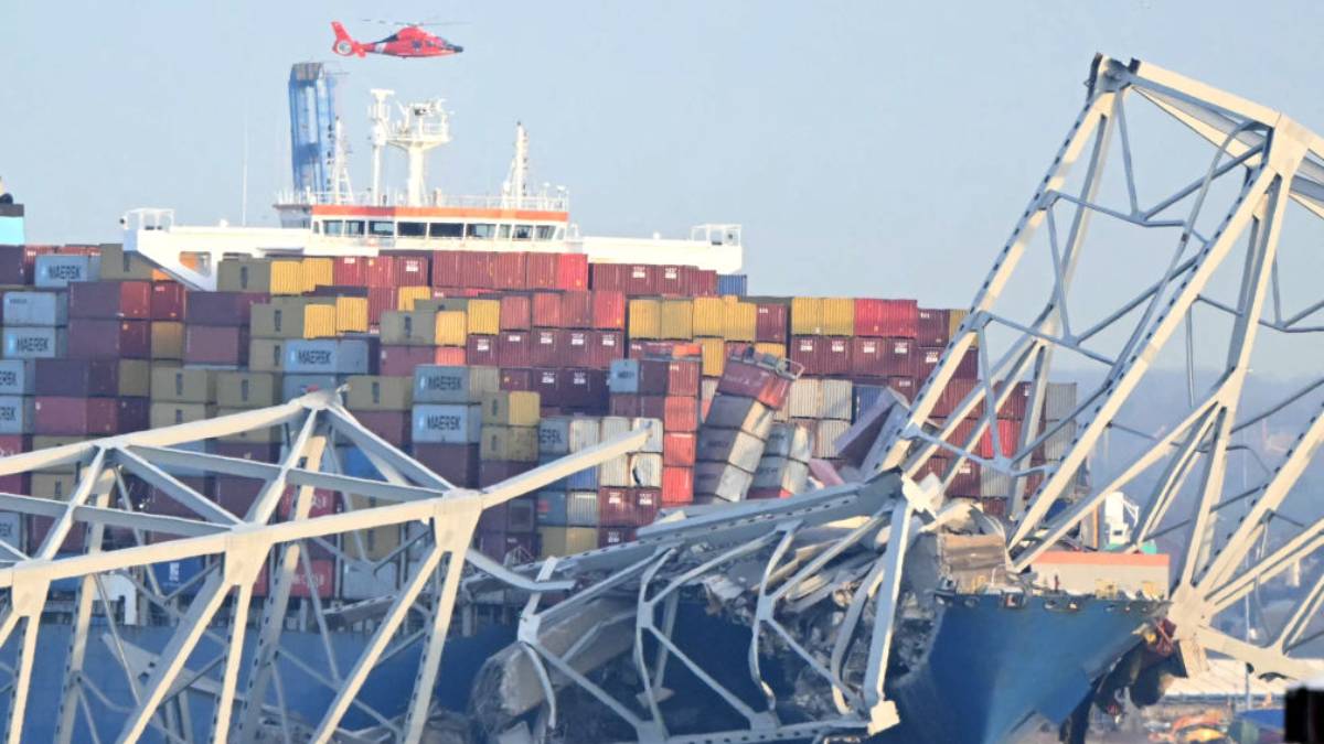 A photo of the Key Bridge collapsed on top of a cargo ship.